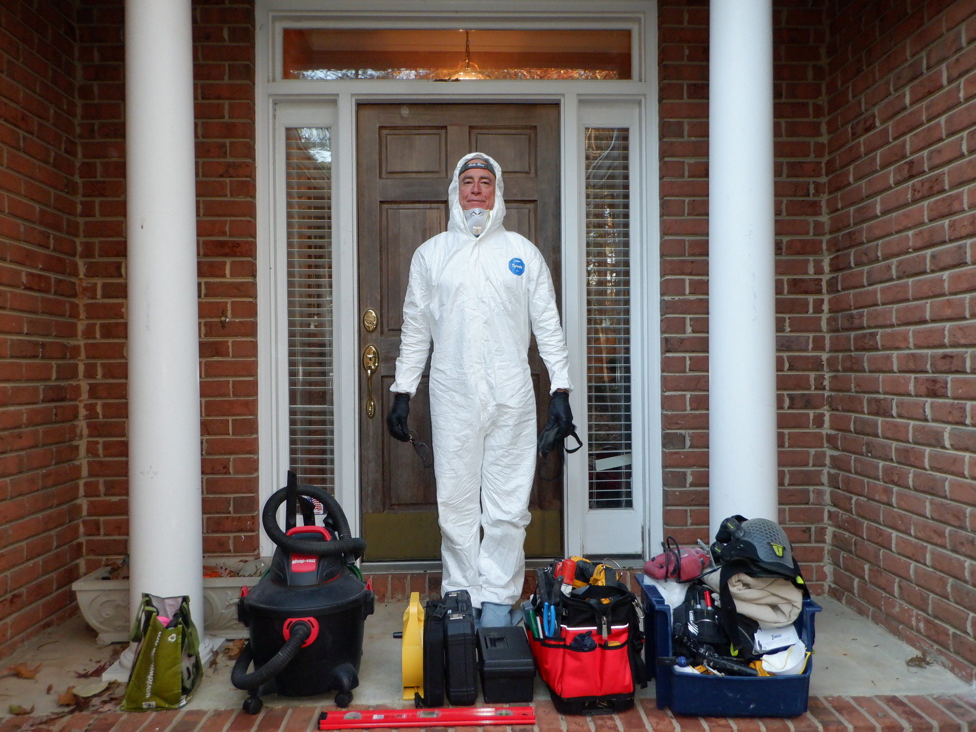 Steve McLeod in Tyvek suit with inspection tools at a home